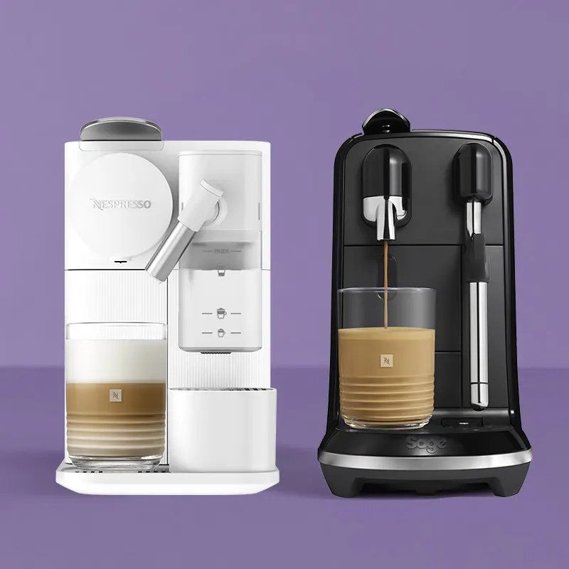 Een witte en een zwarte Nespresso-koffiemachine met stoompijpje, elk met een romige melk-koffiedrank in een glazen beker, op een paarse achtergrond.