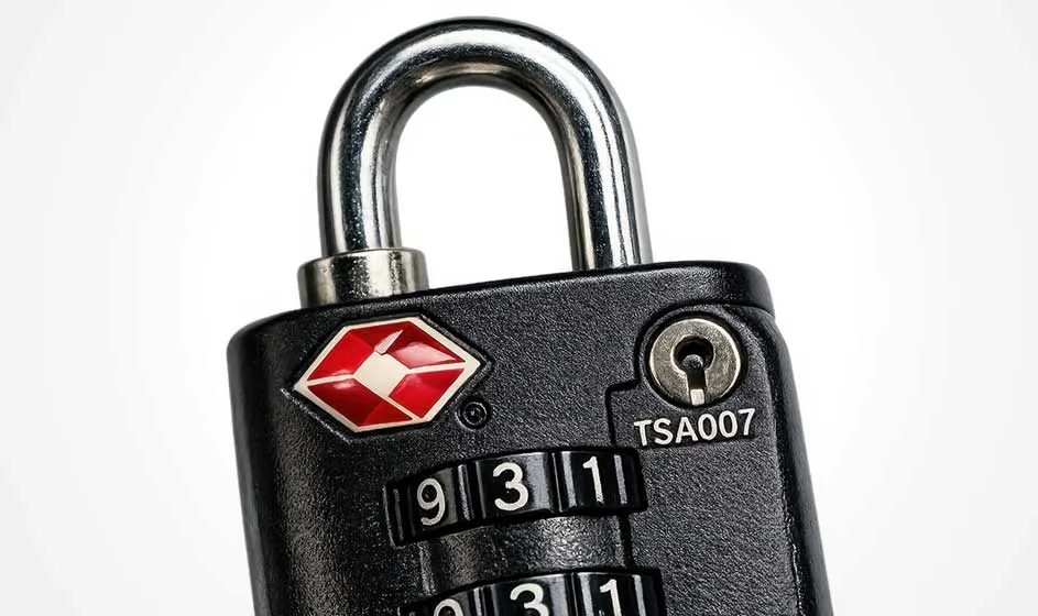 Un cadenas TSA noir à combinaison, avec anse métallique, apparaît en gros plan sur un fond clair.