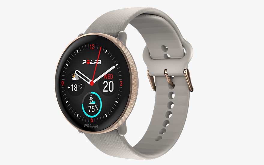 Een Polar-smartwatch met beige band toont de tijd, datum, temperatuur en een sportief voortgangspercentage op een zwarte wijzerplaat.