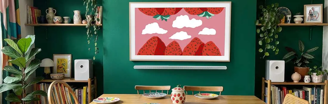 Une salle à manger colorée présente une table en bois, des chaises vintage, des bibliothèques vertes et un grand écran décoratif.