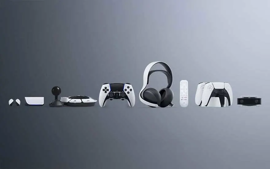 Divers accessoires de jeu vidéo blancs et noirs disposés sur un fond gris. On y trouve un casque, une télécommande et des manettes.