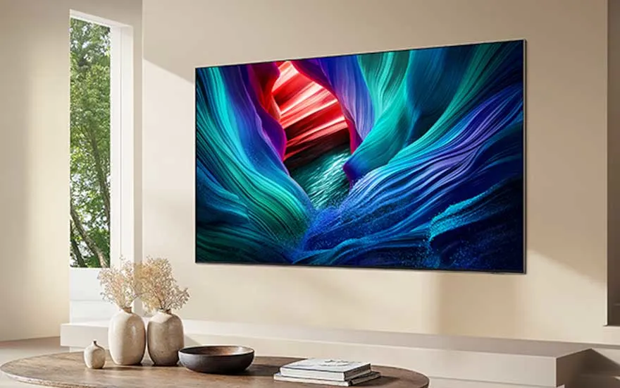Een moderne woonkamer met een wand-tv die een kleurrijk canyonbeeld toont boven een houten tafel met decoratie.