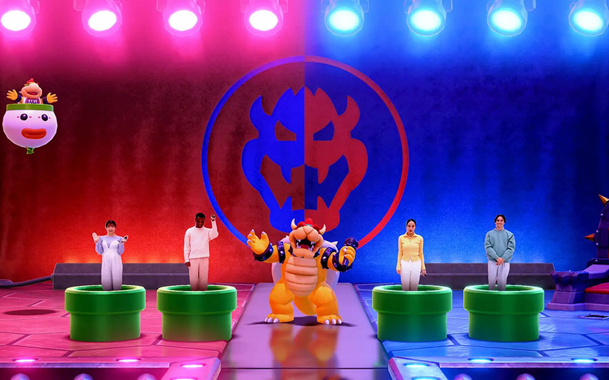 Bowser se tient au centre d'une scène colorée avec quatre joueurs sur des tuyaux verts, sous un éclairage dramatique rouge et bleu.
