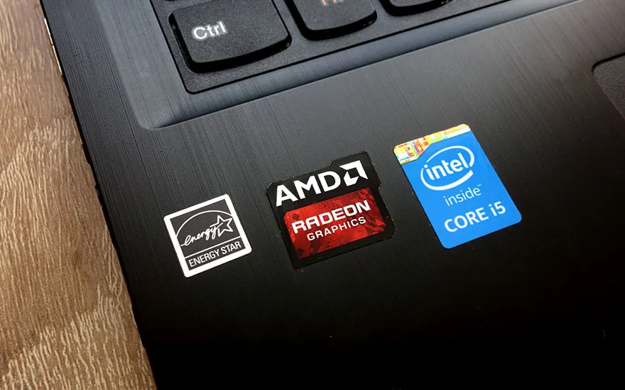 Een close-up van een zwarte laptop met stickers voor Energy Star, AMD Radeon Graphics en Intel Core i5.