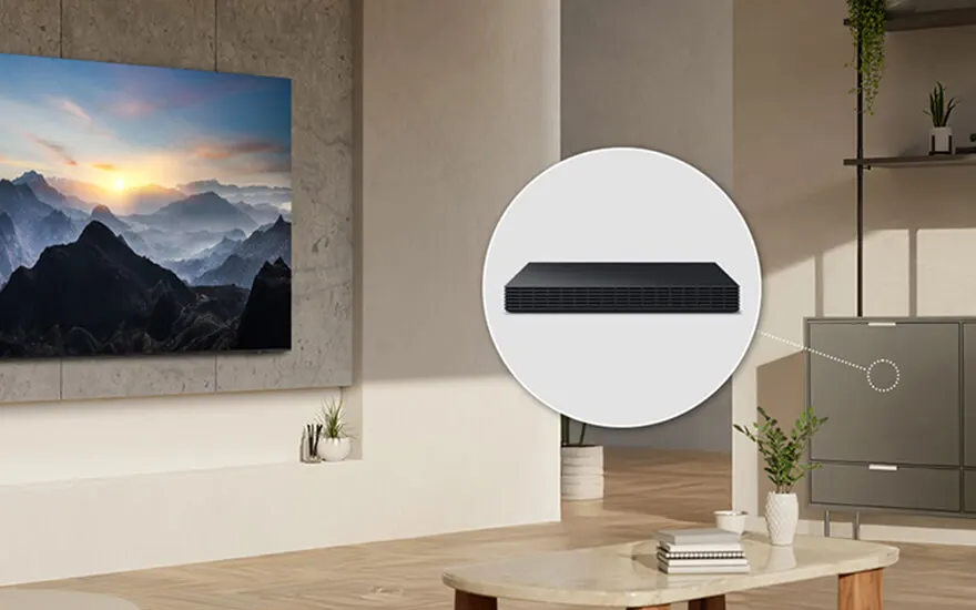 Salon moderne avec une télévision affichant un paysage montagneux et un système audio noir mis en évidence. Mobilier neutre.