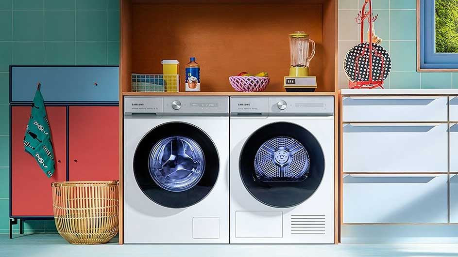 Een wasruimte met twee witte machines, een kast en een rek. Boven de machines staan flessen, een blender en een mand.