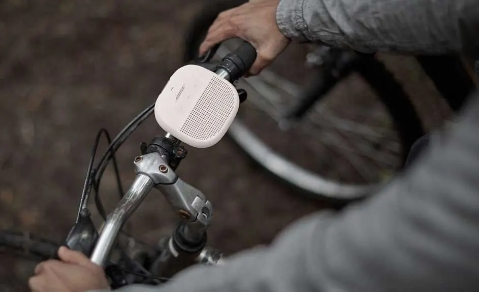 Een witte Bose-luidspreker is bevestigd aan het stuur van een fiets, met handen die het stuur vasthouden.