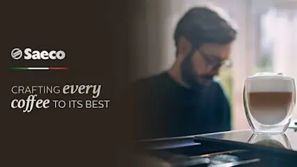 Een glas gelaagde koffie met Saeco-logo op een donkere achtergrond. De tekst luidt: "Crafting every coffee to its best".