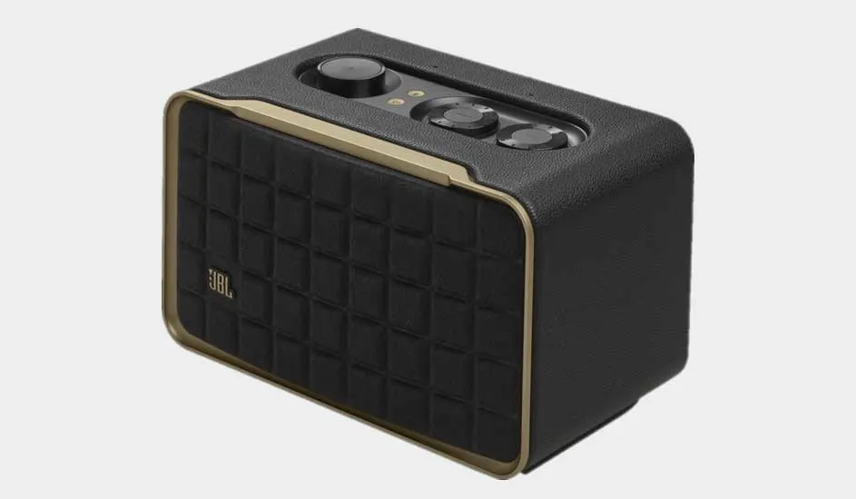 Een zwarte JBL-luidspreker met gouden randen, met bedieningsknoppen aan de bovenzijde, op een witte achtergrond.