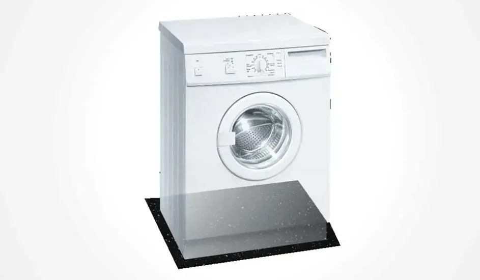 Een witte wasmachine staat op een zwart dempend plateau, het bedieningspaneel en de deur zijn duidelijk zichtbaar, merk is niet zichtbaar.