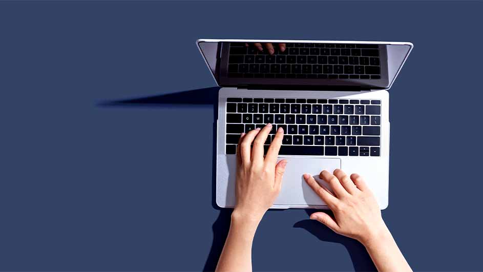 Vue du dessus d'un ordinateur portable blanc avec clavier noir sur fond bleu.