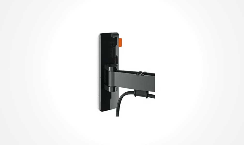 A black TV mount is affixed to a white wall with a cable hanging from it.