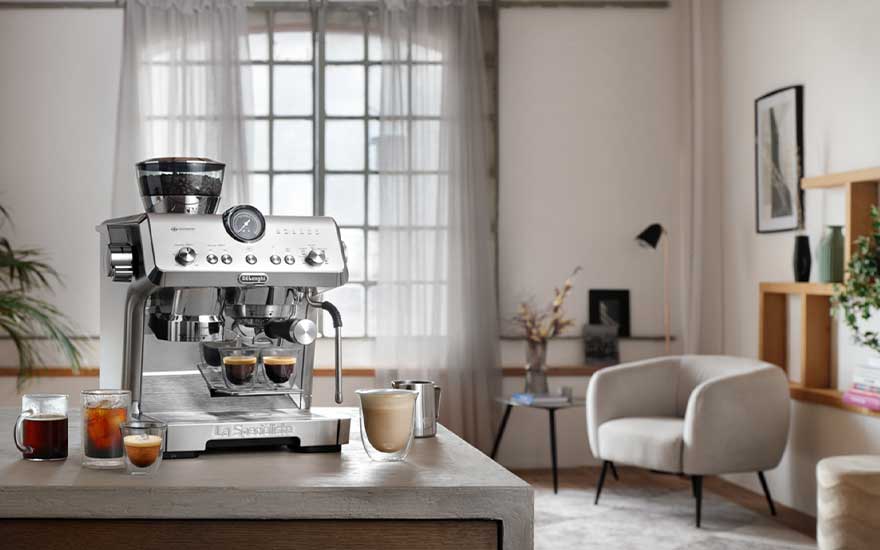 DeLonghi La Specialista-espressomachine op het aanrecht in een lichte lounge, omringd door uitnodigende koffiedranken op tafel.
