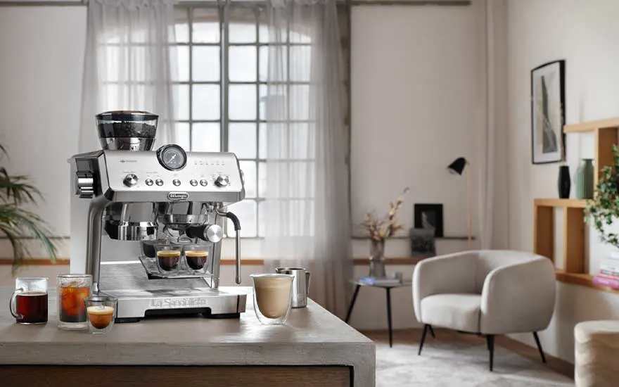 DeLonghi La Specialista-espressomachine op het aanrecht in een lichte lounge, omringd door uitnodigende koffiedranken op tafel.