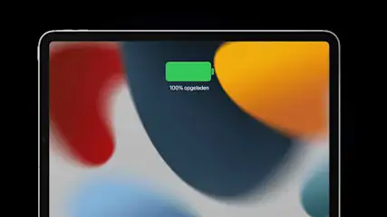 Een tablet in portretmodus toont een abstracte achtergrond met een groene batterij-indicator die 100% opgeladen aangeeft.