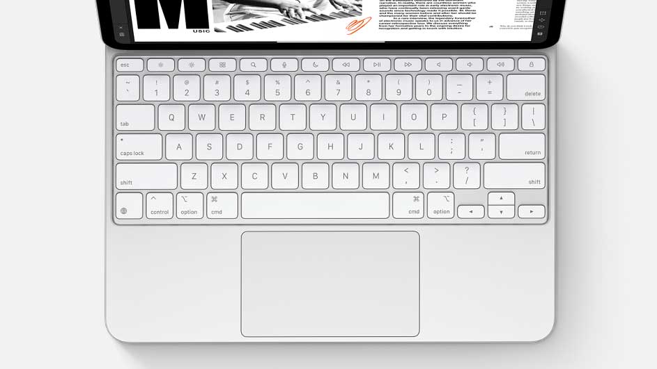 Vue de dessus d'un clavier blanc avec pavé tactile intégré, connecté à une tablette affichant du texte et une image en noir et blanc.