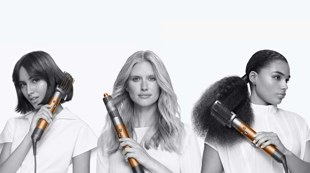 Drie personen met een Dyson Airwrap. De achtergrond is wit. De personen hebben verschillend haar.