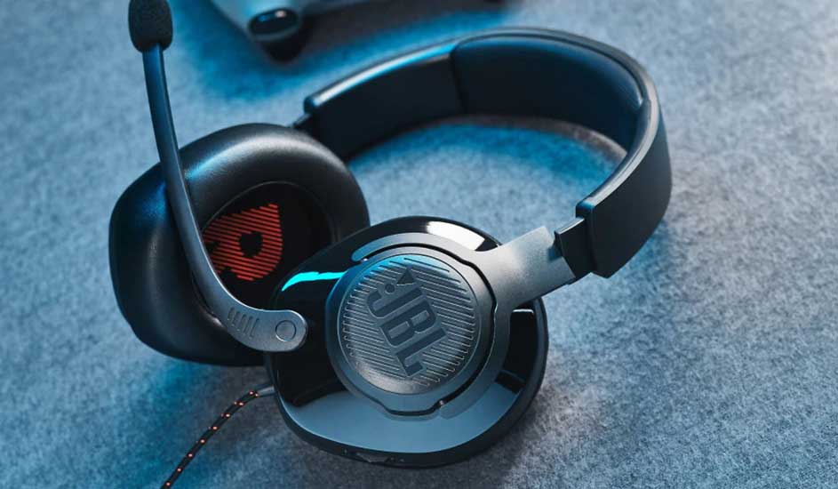 Casque noir JBL avec micro sur tissu gris. Détails orange et bleus.