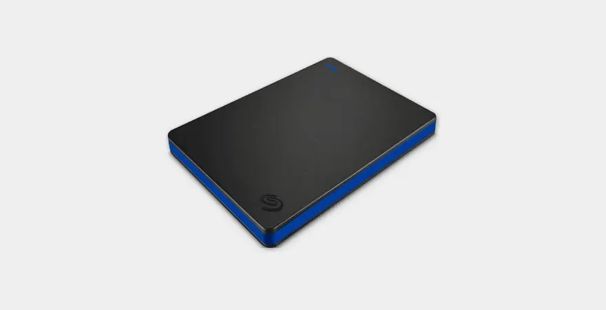 Un disque dur externe noir avec une bordure bleue repose sur une surface blanche unie.