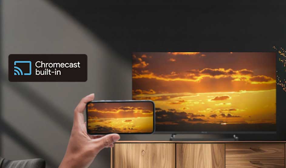 Een PEAQ TV toont dezelfde zonsondergang als op een smartphone; links staat het “Chromecast built-in” logo in beeld.