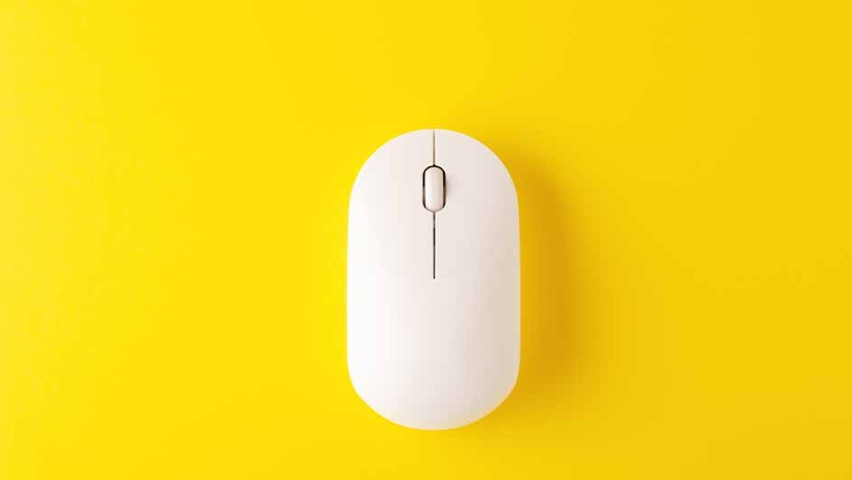 Une souris blanche d'ordinateur est posée sur un fond jaune uni. La souris est centrée et orientée verticalement.