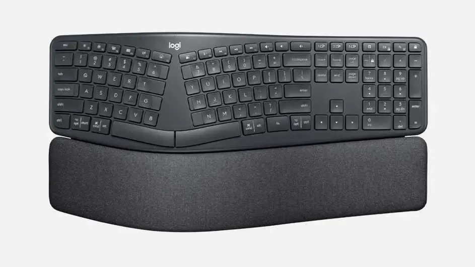A dark grey ergonomic Logitech keyboard with curved shape and soft wrist rest for comfortable typing experience.