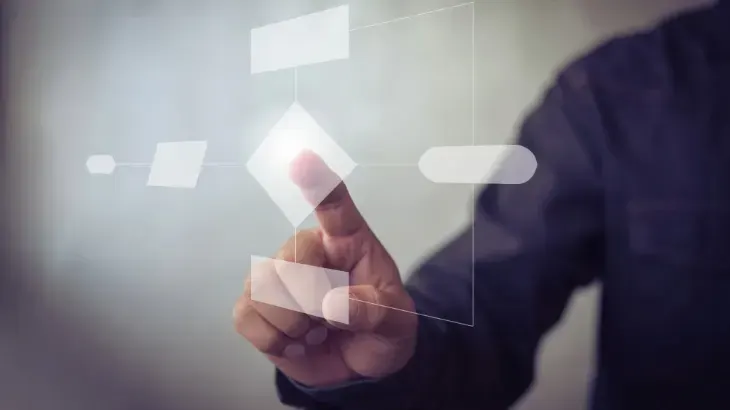 Hand pointing at a digital diagram on a transparent screen.