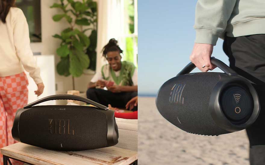 Zwart JBL-luidspreker met handvat, binnenshuis op een houten tafel en buitenshuis in de hand op een zandstrand.
