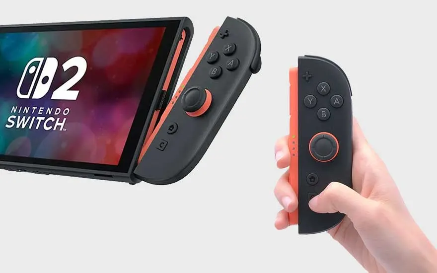 A Nintendo Switch with dark-grey controllers with orange trim is shown with a colorful screen. One controller is held in a hand.