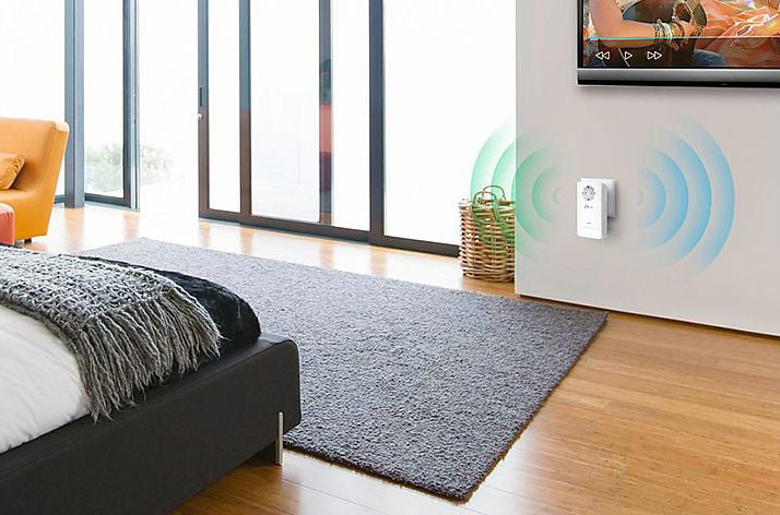 Een interieur met een grijs tapijt, houten vloer, en een witte wifi-versterker aan de muur met blauwe signalen.