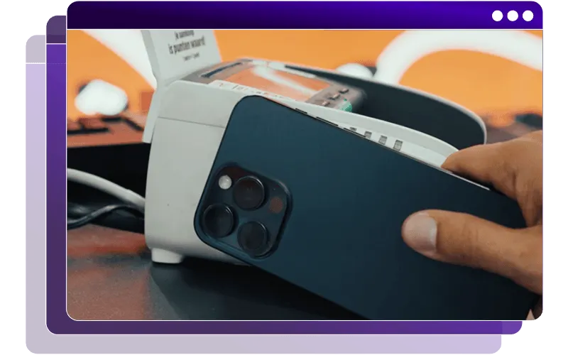 A hand holding a smartphone next to a label printer, shown inside a purple browser frame.