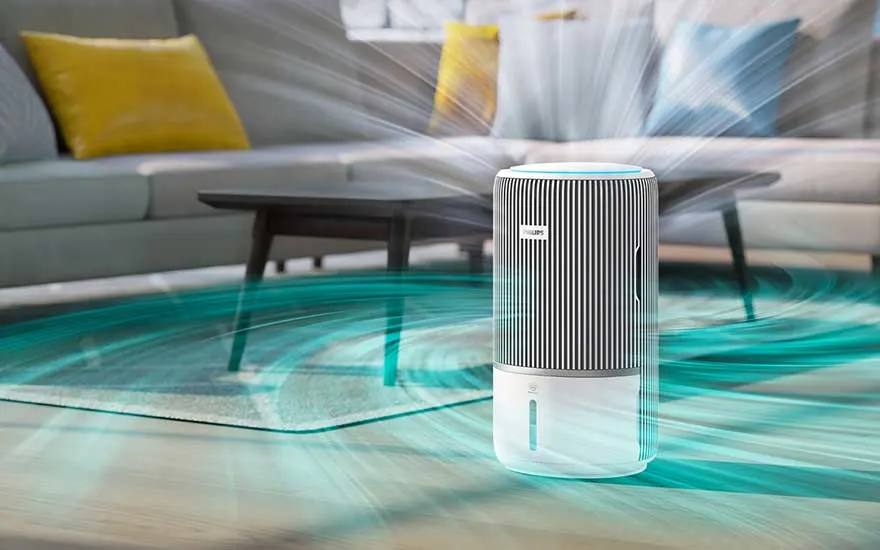 Dans un salon coloré, un purificateur à rayures diffuse de puissants flux turquoise qui tourbillonnent autour de la table basse et du canapé.