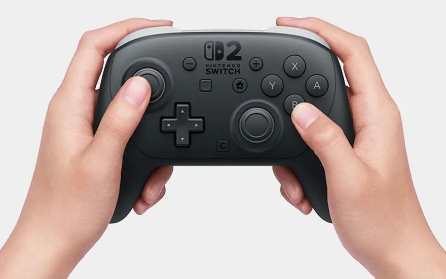 Deux mains tiennent fermement une manette Nintendo Switch Pro noire, prêtes à jouer.