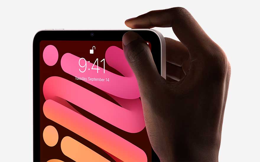 Een hand drukt op de aan/uit-knop van een tablet. Het scherm toont een abstract roze en oranje ontwerp.