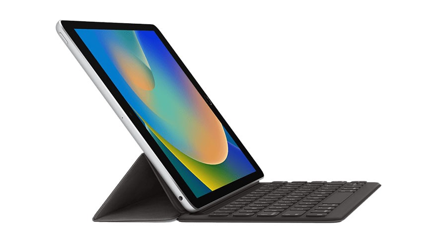Tablette argentée inclinée avec un écran multicolore et un clavier noir sur un fond blanc.