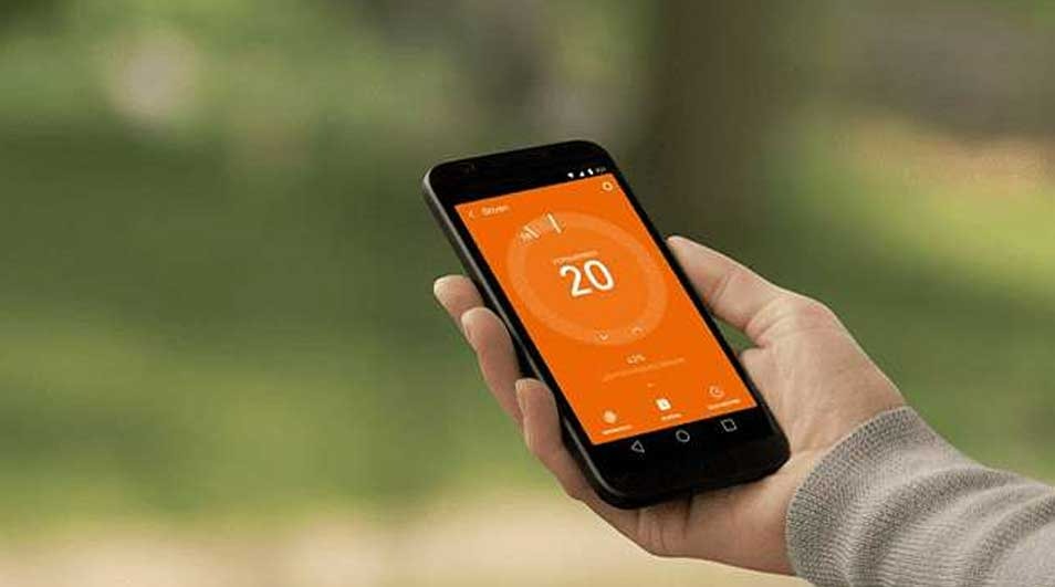 Een zwarte smartphone met een oranje scherm met het nummer 20 wordt vastgehouden tegen een groene achtergrond.