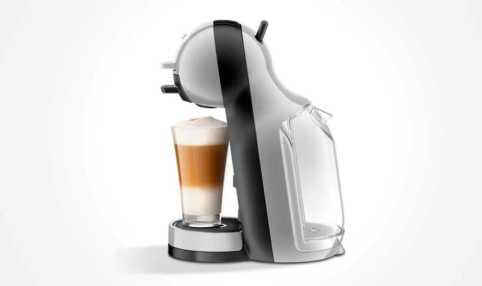 Une machine à café blanche et noire vue de côté remplit un grand verre de latte, avec réservoir à lait visible sur fond blanc.