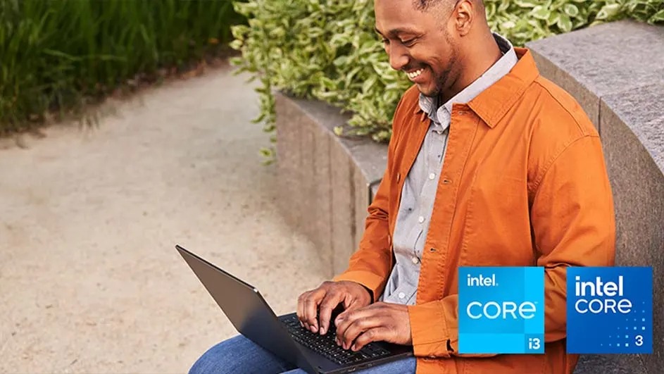 Een laptop wordt buitenshuis gebruikt, met groene planten en een stenen muur op de achtergrond. Intel Core i3 logo zichtbaar.