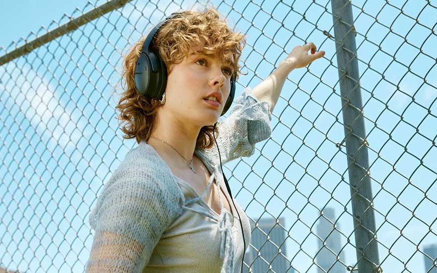 A yellow jacket over a purple shirt. Buildings and mountains in the background.