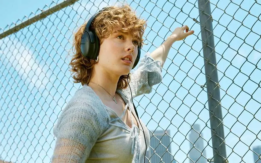 A yellow jacket over a purple shirt. Buildings and mountains in the background.