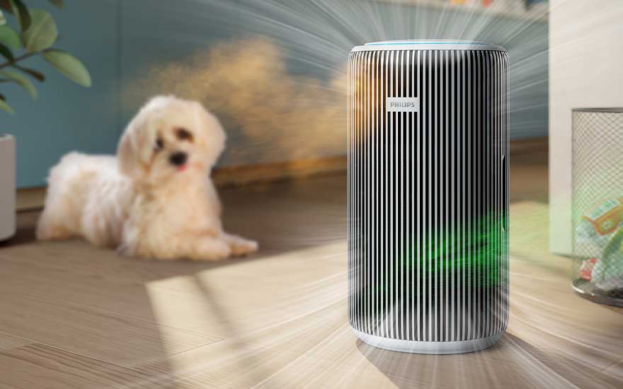Un petit chien blanc se repose au sol, tandis qu’un purificateur Philips aspire les odeurs colorées de l’animal et de la poubelle pour assainir l’air.