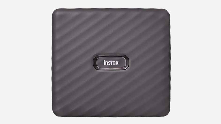 Een vierkante, paarse Instax-printer met een ruitpatroon en een logo, geplaatst op een witte achtergrond.