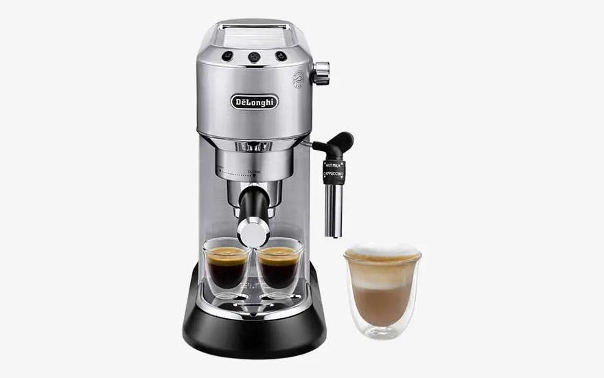 A silver De’Longhi espresso machine pours two espressos, with a steam wand and a separate glass cup filled with foamy milk.