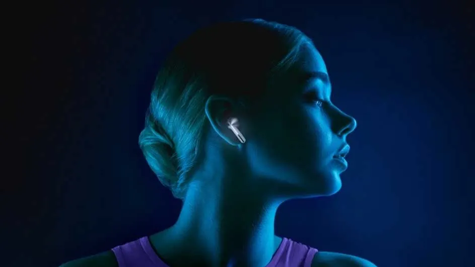 Profiel in blauw licht. Een wit oortje is zichtbaar in het oor. De achtergrond is donkerblauw.