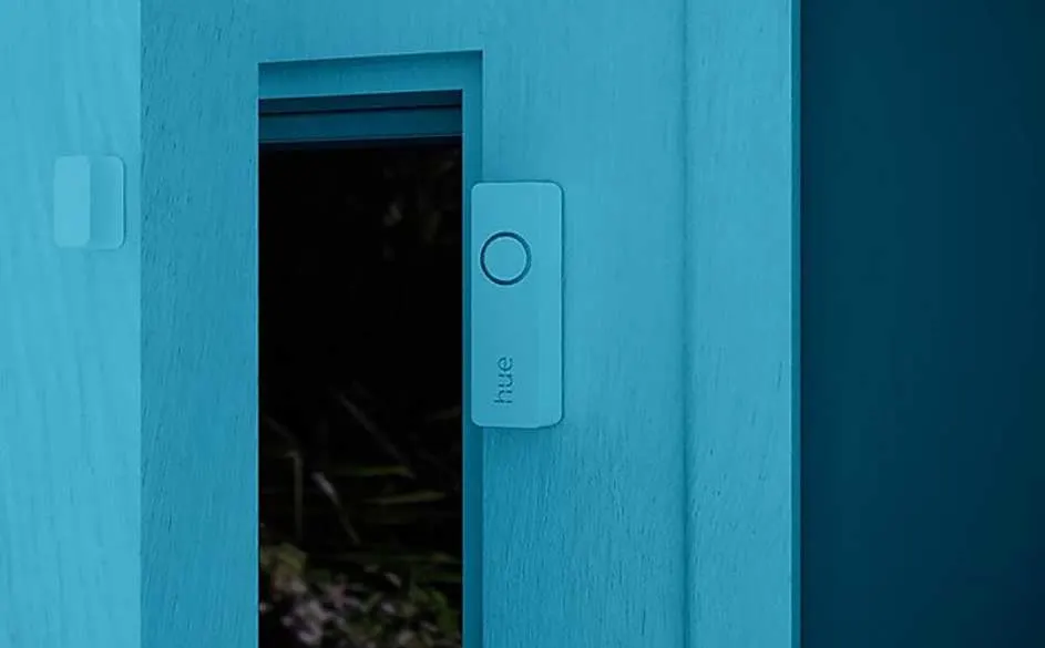 Un mur bleu avec un interrupteur "Hue" à côté d'une ouverture sombre, possiblement une fenêtre.