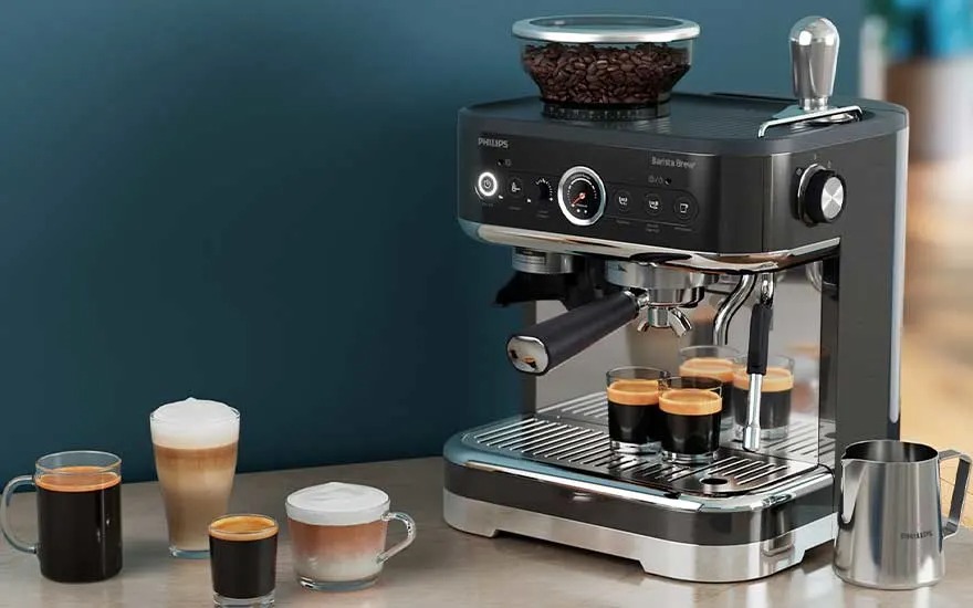 Zwarte espressomachine met bonenbak bovenop, zet meerdere kopjes terwijl verschillende melk‑ en koffiedranken op het aanrecht staan.