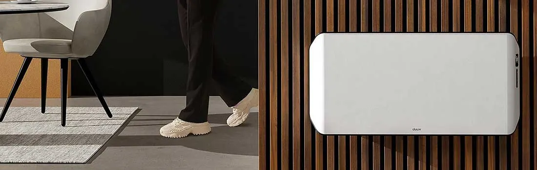 A room view with a chair on a rug, pants and shoes, and a white radiator against a wood slat wall.