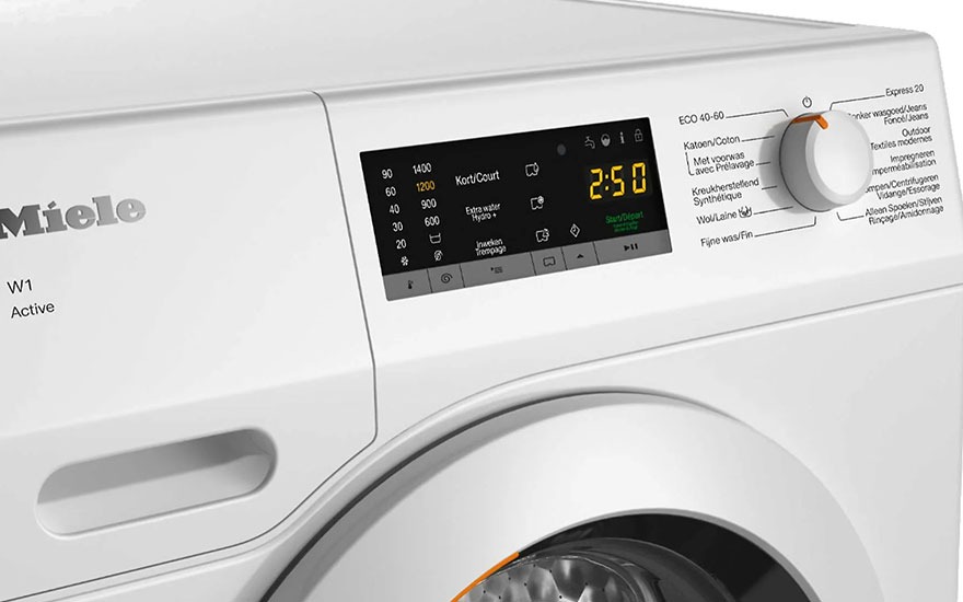 Vue rapprochée d'un lave-linge Miele blanc avec écran affichant "2:50", un sélecteur de programme et des options de lavage.