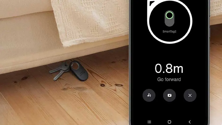 Sleutels onder een houten bed, getoond via een smartphone app die de locatie aangeeft op 0.8m afstand.
