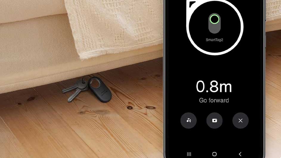 Clés et SmartTag sous un meuble, visibles via un smartphone affichant "SmartTag2" et "0.8m".